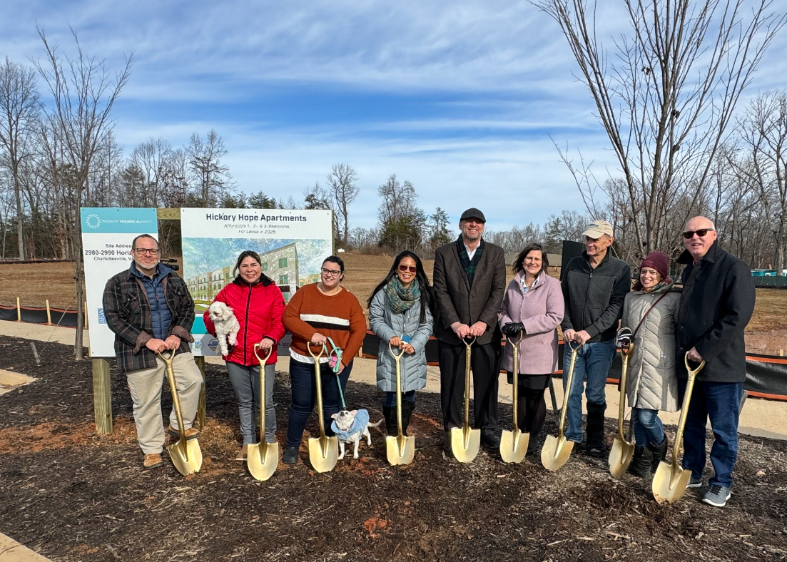group of men and women lined up posing and smiling with golden shovels